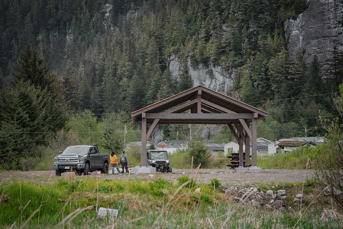 Open-air custom timber frame structure in Northern BC setting, built by Smith Timber Works, ideal for outdoor shelter or group gathering space.