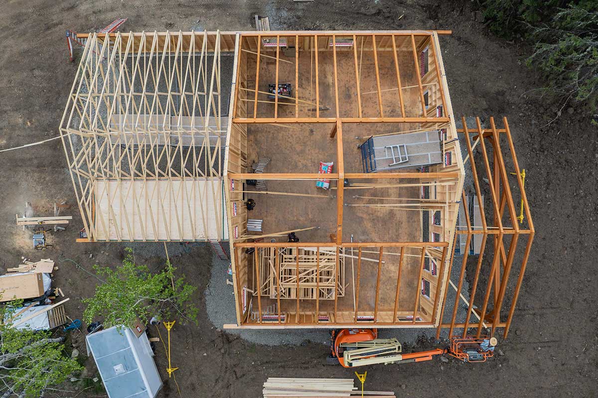 From above, a timber frame house under construction by Smith Timber Works, British Columbia. Aerial view of timber frame house construction by Smith Timber Works.