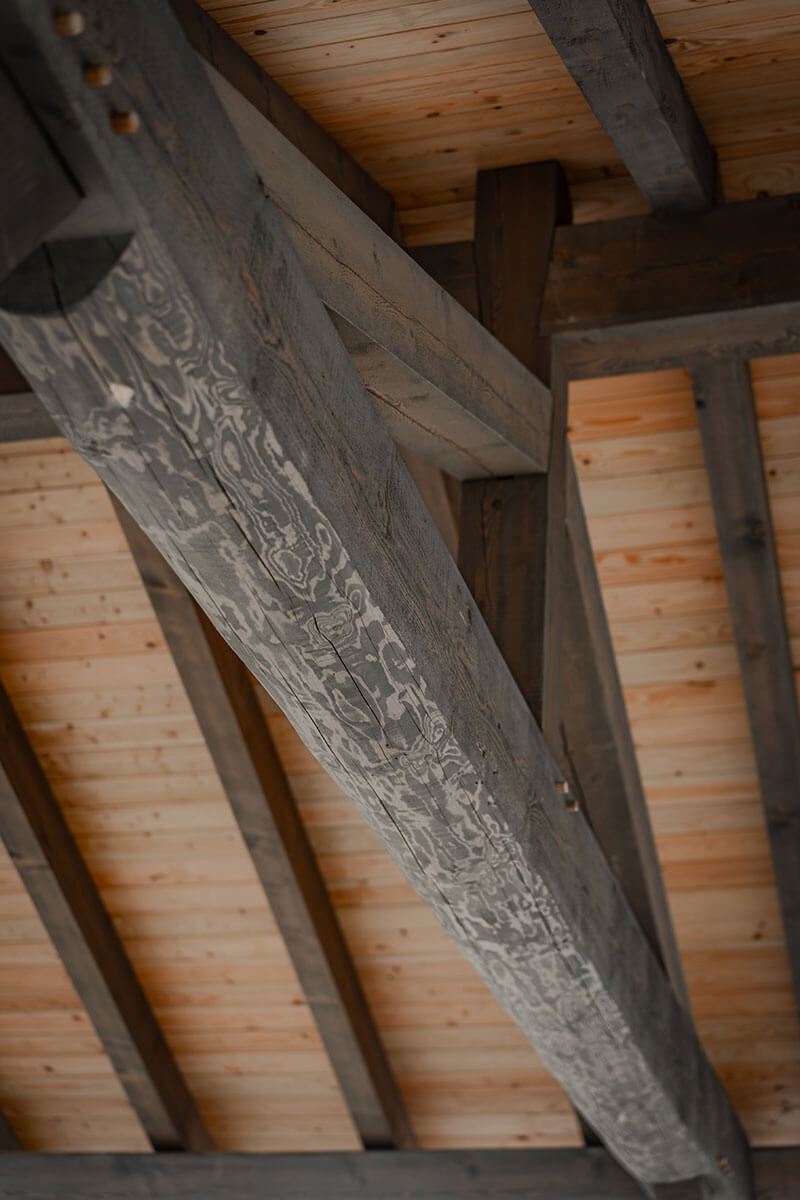 Rustic interior timber frame beam with visible wood grain and classic joinery, showcasing enduring craftsmanship by Smith Timber Works.