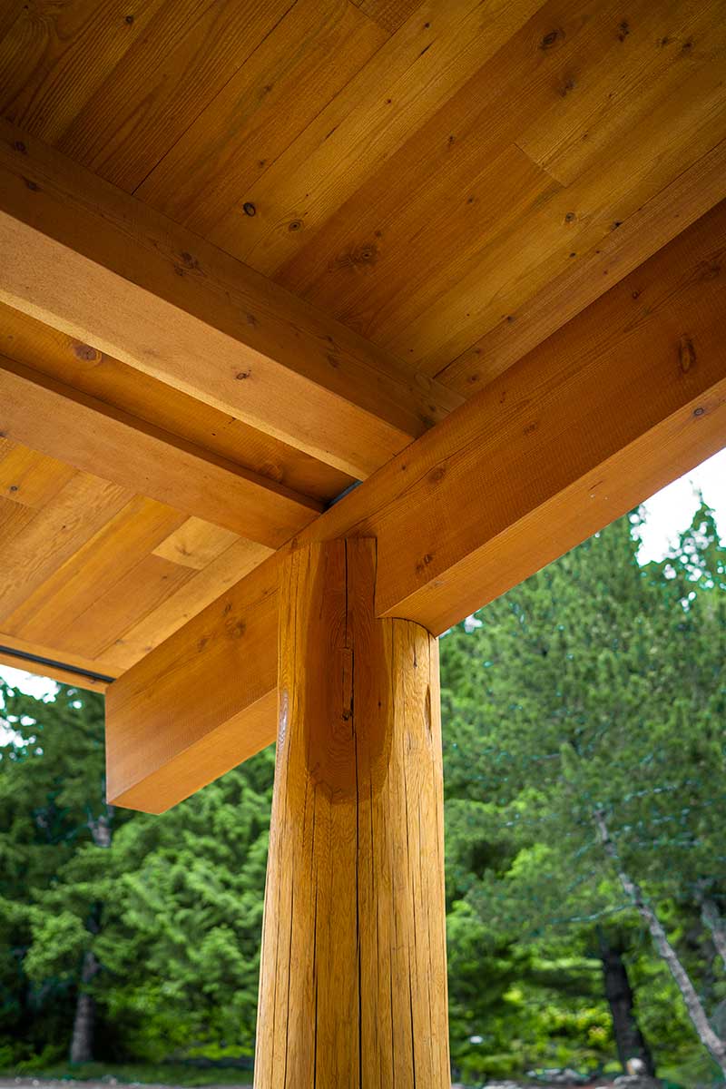 Detail of a robust timber column and exposed beam on a custom structure by Smith Timber Works, showcasing the warm tones of natural wood and precise joinery.