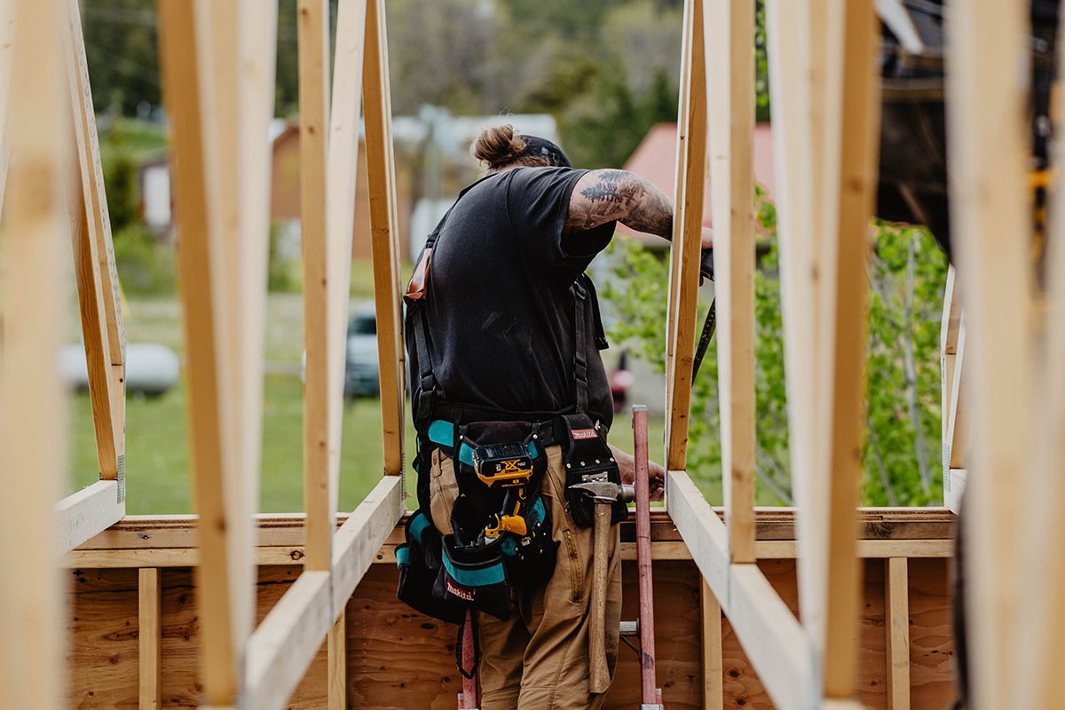 Smith Timber Works carpenter installing a truss roof section with precision on a residential timber build in British Columbia.