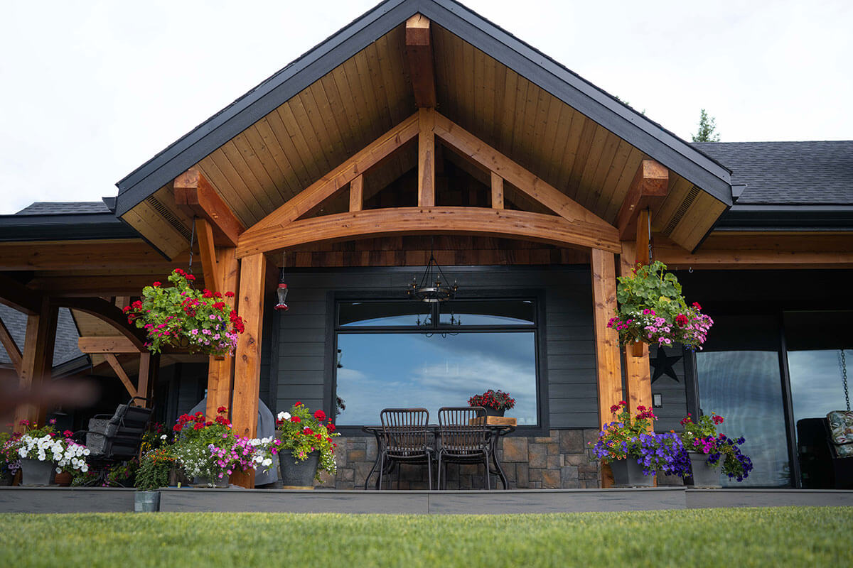 Grand timber frame entrance with exposed trusses and natural wood, showcasing custom design and craftsmanship by Smith Timber Works in British Columbia.