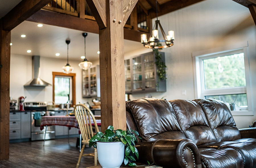 Open concept living space with exposed timber framing by Smith Timber Works, British Columbia.