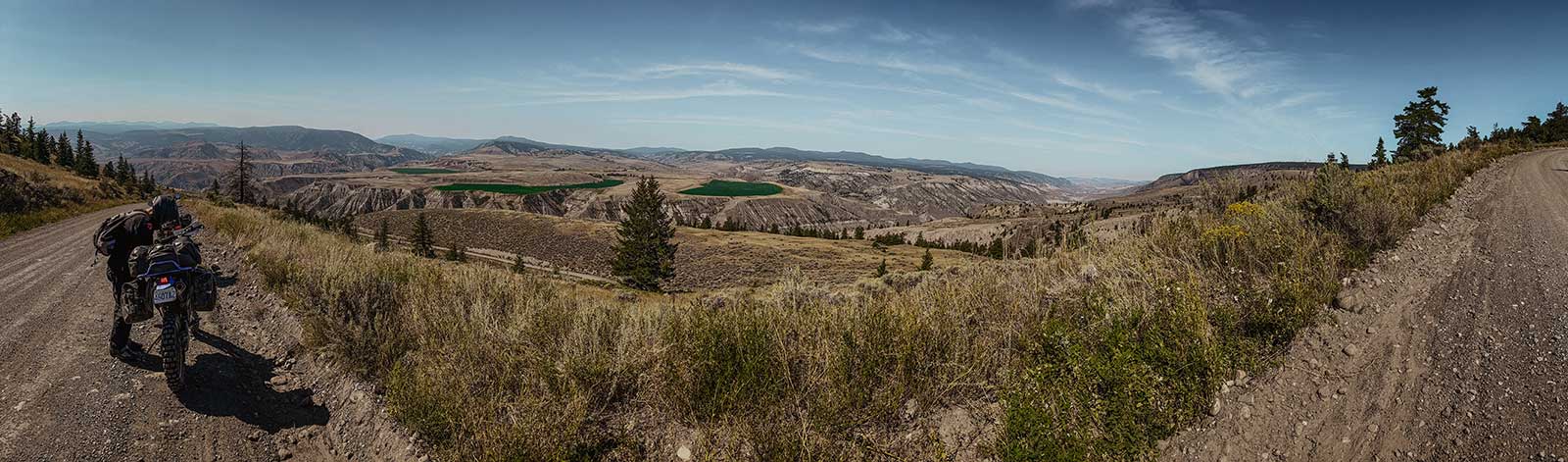 Panoramic view of British Columbia backcountry trails with motorcyclists, capturing the spirit of exploration that drives Smith Timber Works.