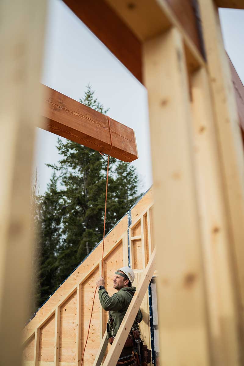 Smith Timber Works crew lifting a timber beam on a construction site.