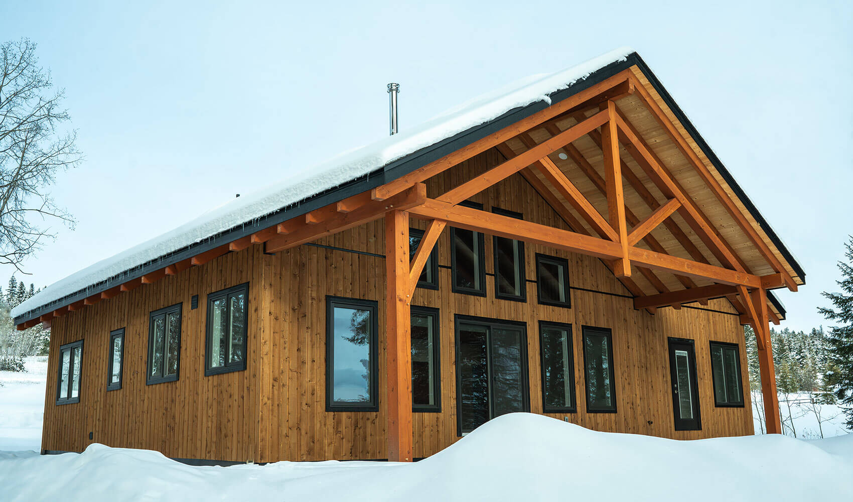 Prefabricated timber frame house in snow by Smith Timber Works, British Columbia.