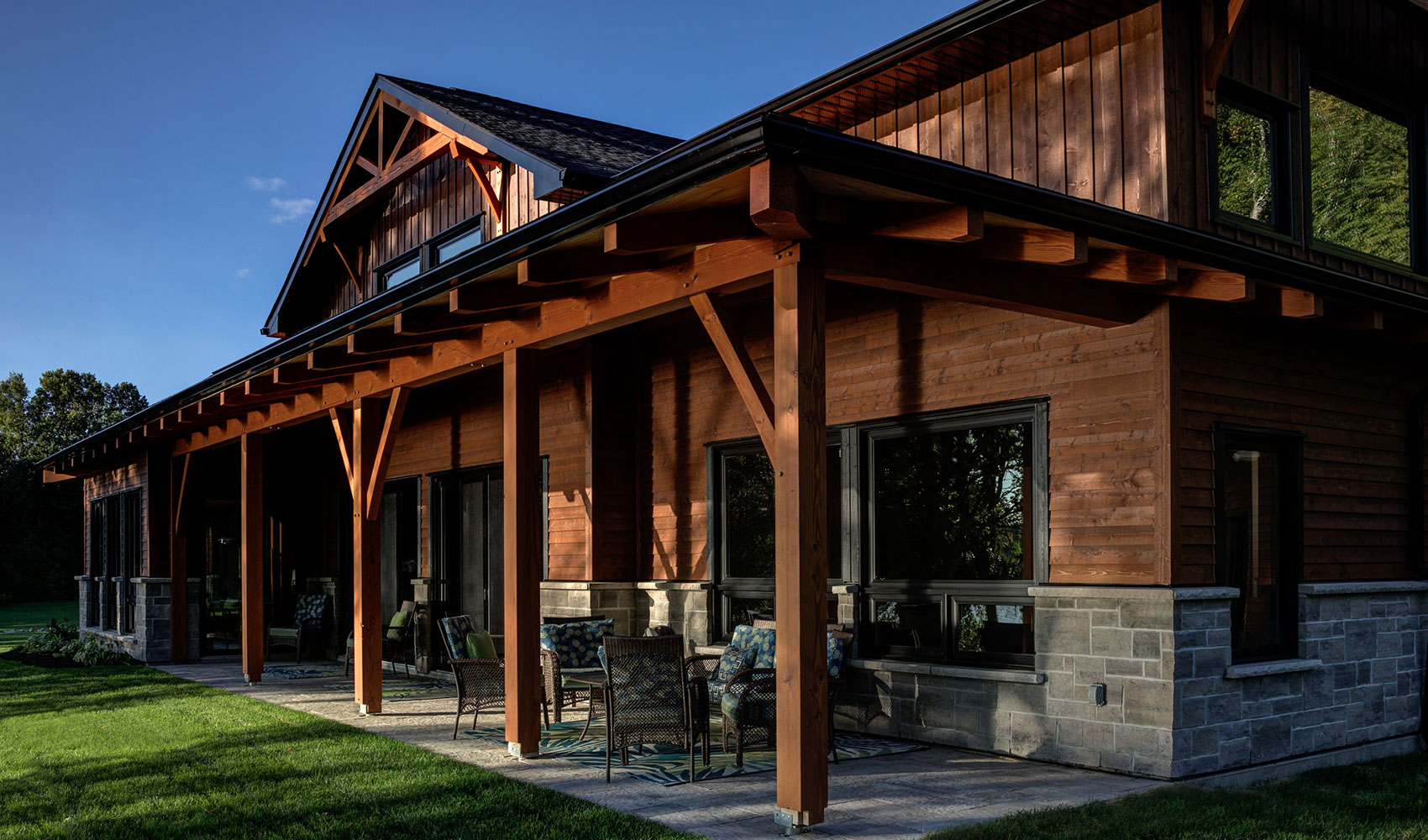 Custom timber frame home with exposed wood beams and stone accents, designed and built by Smith Timber Works.
