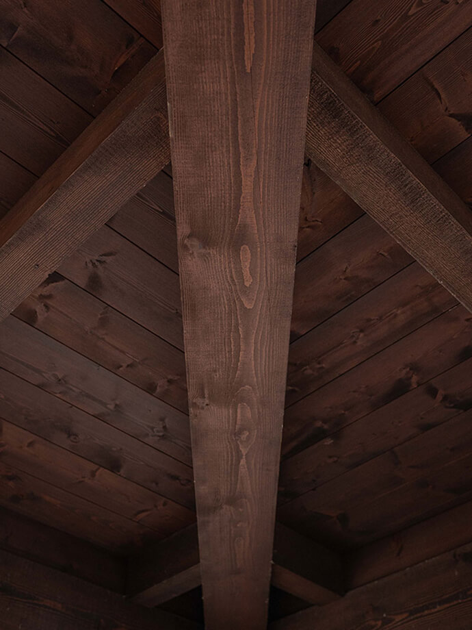 Dark-stained timber ceiling with exposed beam joinery, highlighting Smith Timber Works’ fine wood finishing and structural craftsmanship.