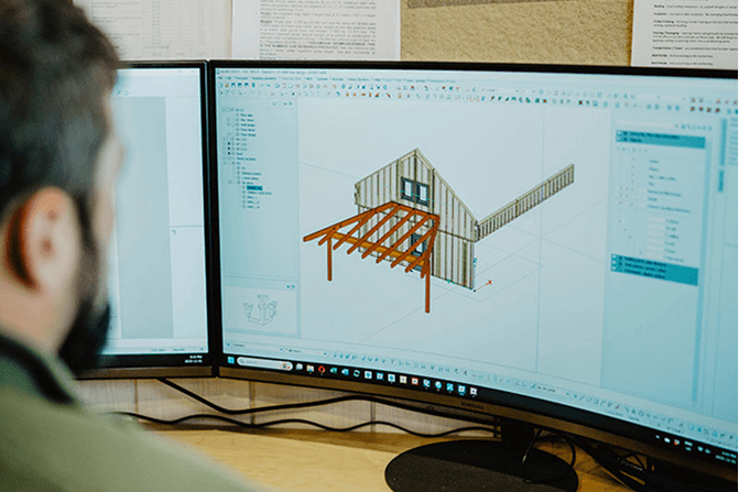 Designer using 3D modeling software to develop timber frame structures at Smith Timber Works’ design office.