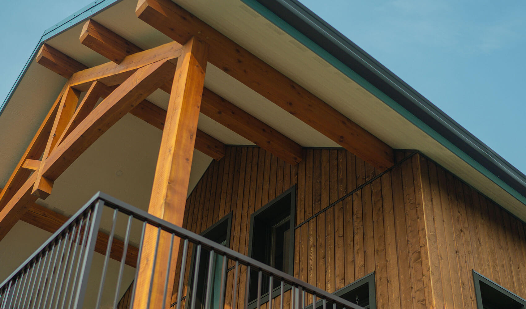 Timber frame detail of gabled roof with exposed beams and vertical cedar siding, built by Smith Timber Works.