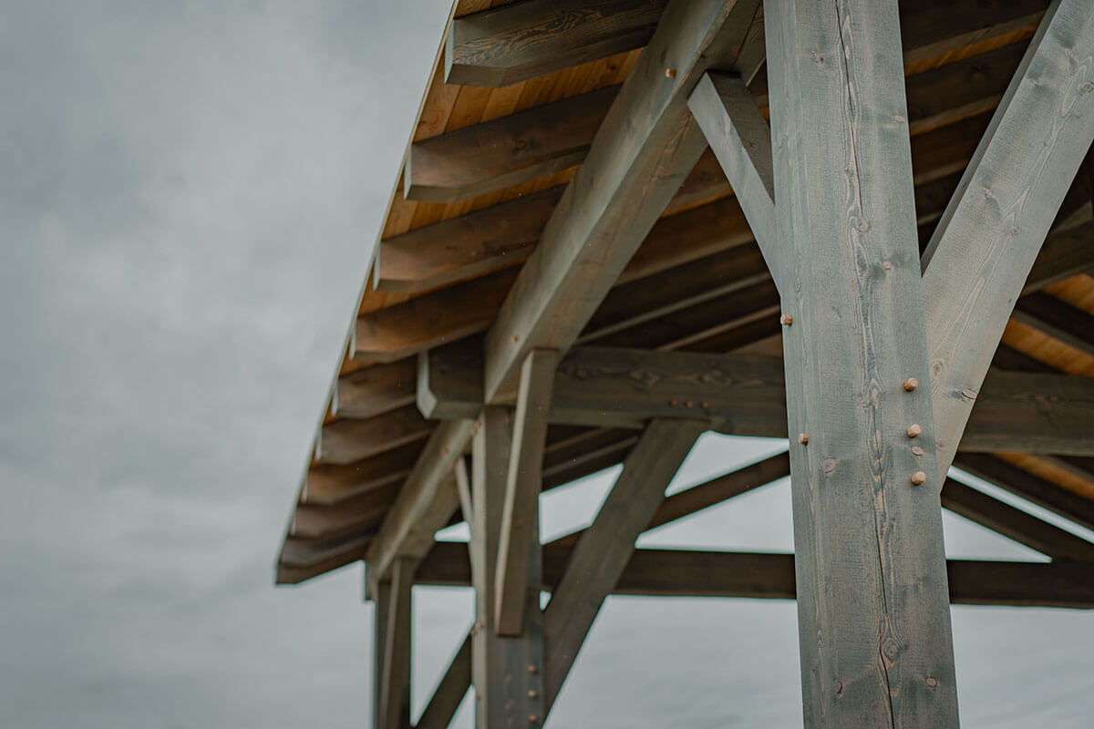 Detail of a robust timber frame structure with visible wood grain and skilled joinery, representing Canadian craftsmanship by Smith Timber Works.