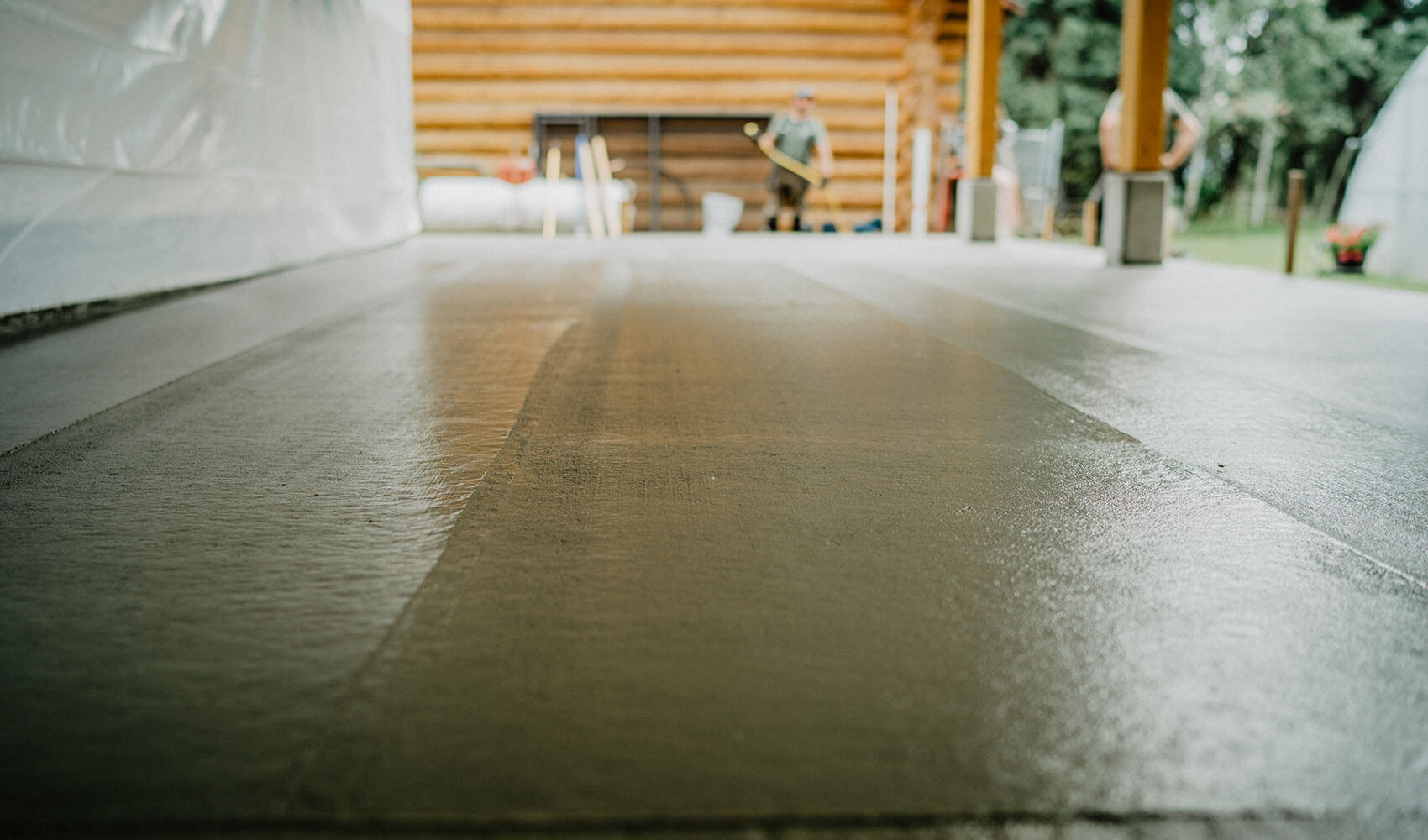 Newly poured concrete slab, a foundation for a Canadian timber frame structure by Smith Timber Works, showcasing the initial stages of a custom build project in British Columbia.