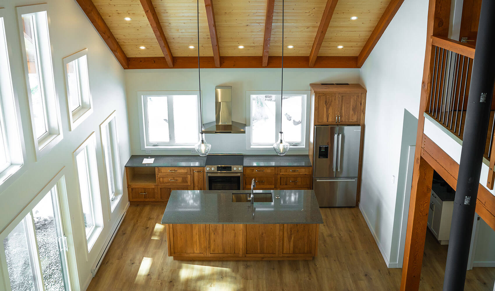 Bright kitchen with exposed timber beams and vaulted ceiling by Smith Timber Works.