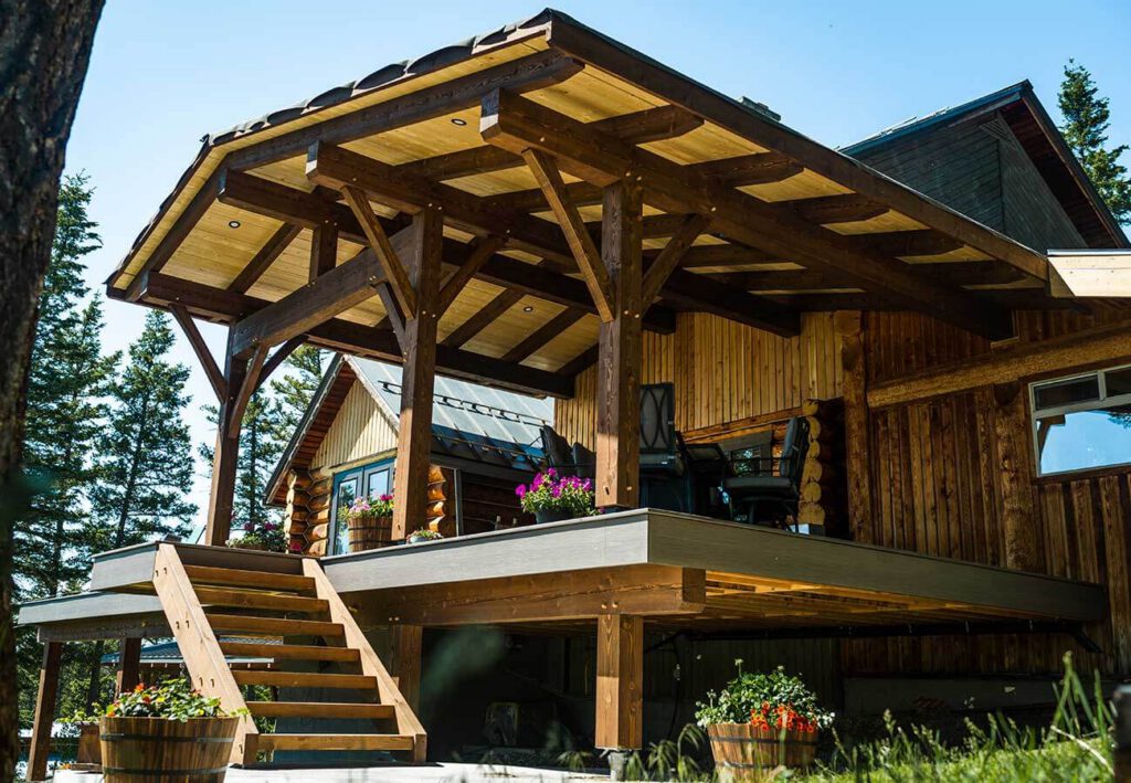 Beautiful Canadian timber frame deck and outdoor living space by Smith Timber Works, featuring exposed wood beams, a covered patio, and stairs, showcasing custom design and craftsmanship in British Columbia.
